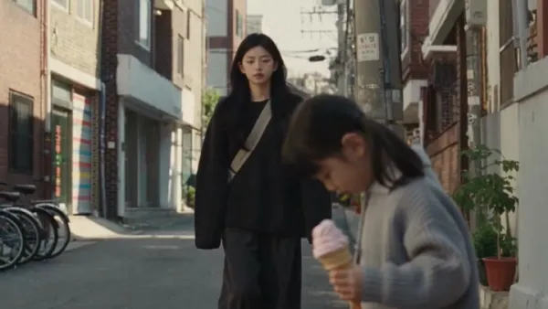 穿酒红卫衣的年轻女子走在首尔安静老街区
