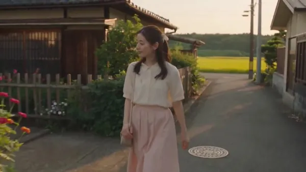金色黄昏下穿粉色长裙的韩国女孩漫步传统村落